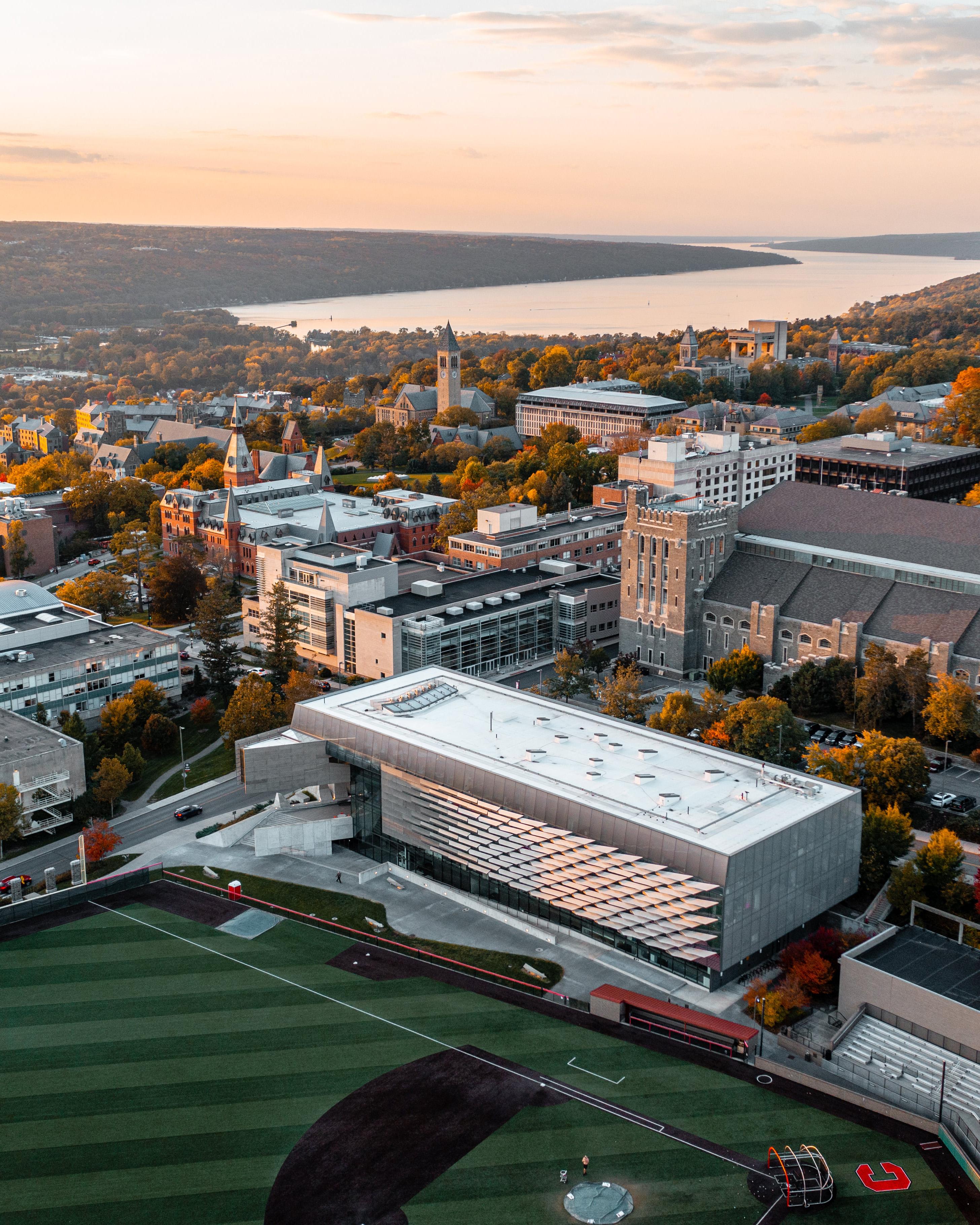 An aerial photo of the Cornell Ithaca campus in Ithaca, looking down on gates hall with mcgraw tower and cayuga lake in the distance