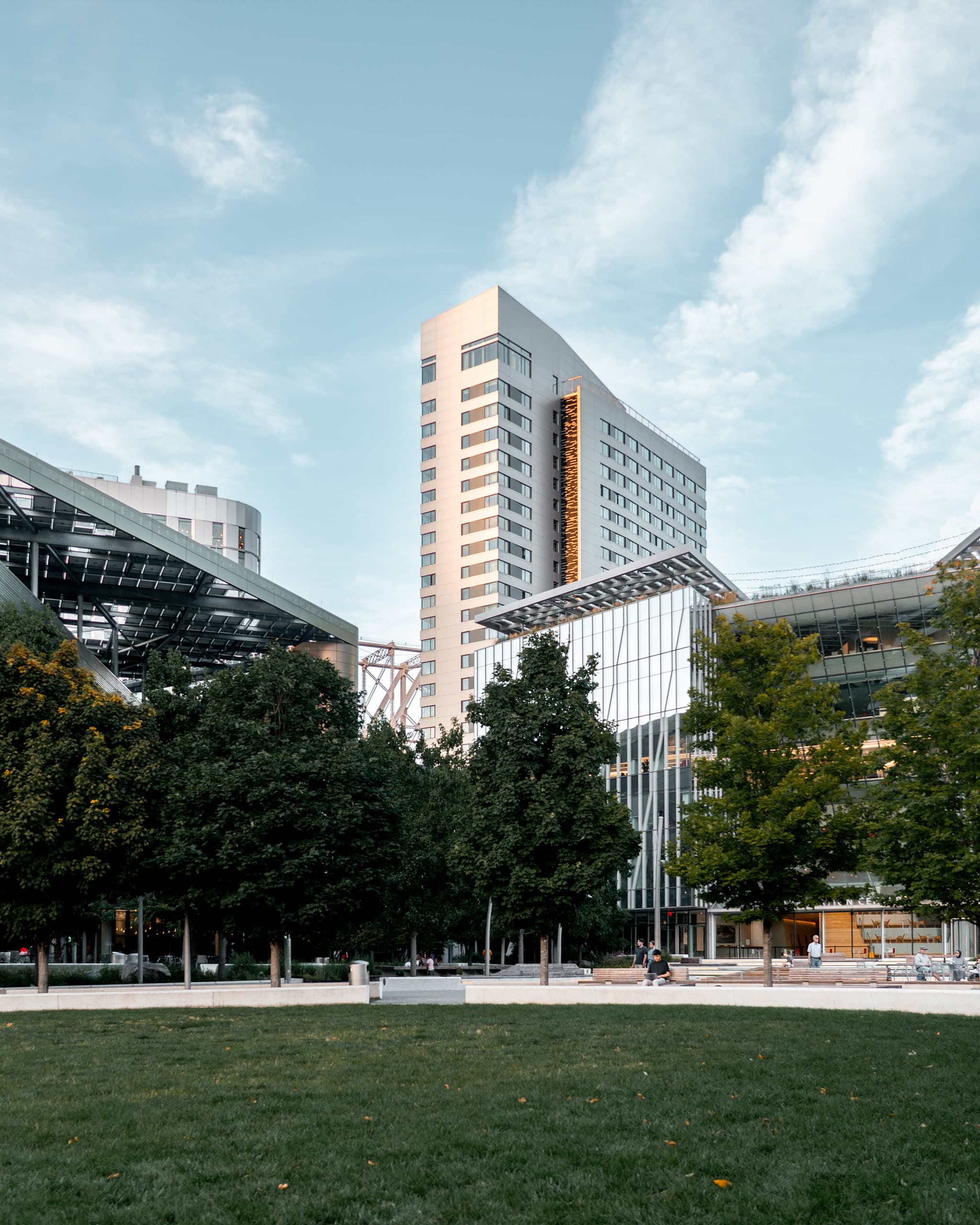 A photo of the Cornell Tech campus in New York City, looking down the main throughway with the Queensborough bridge in the background
