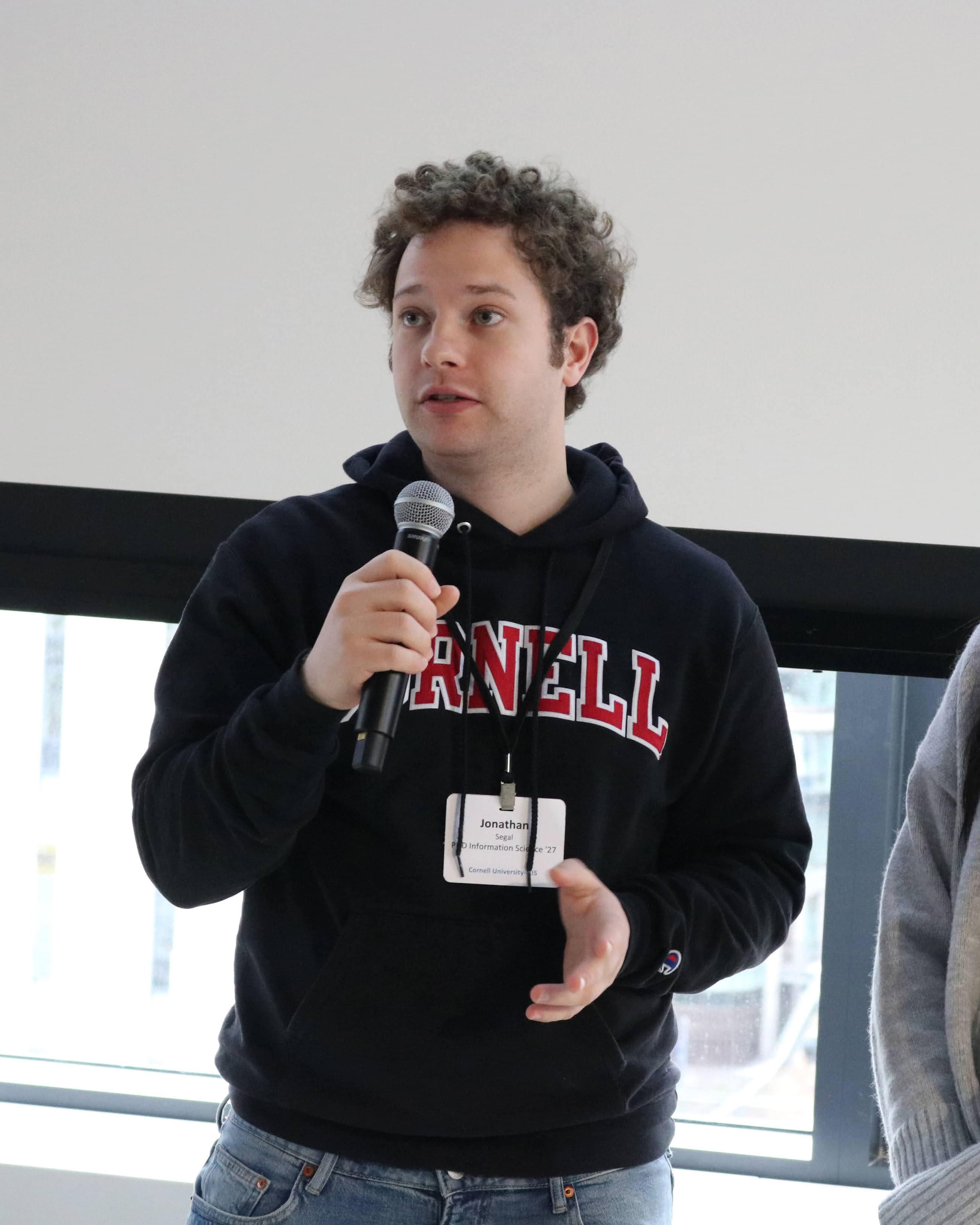 Presenting at a Cornell Tech event, speaking into a microphone